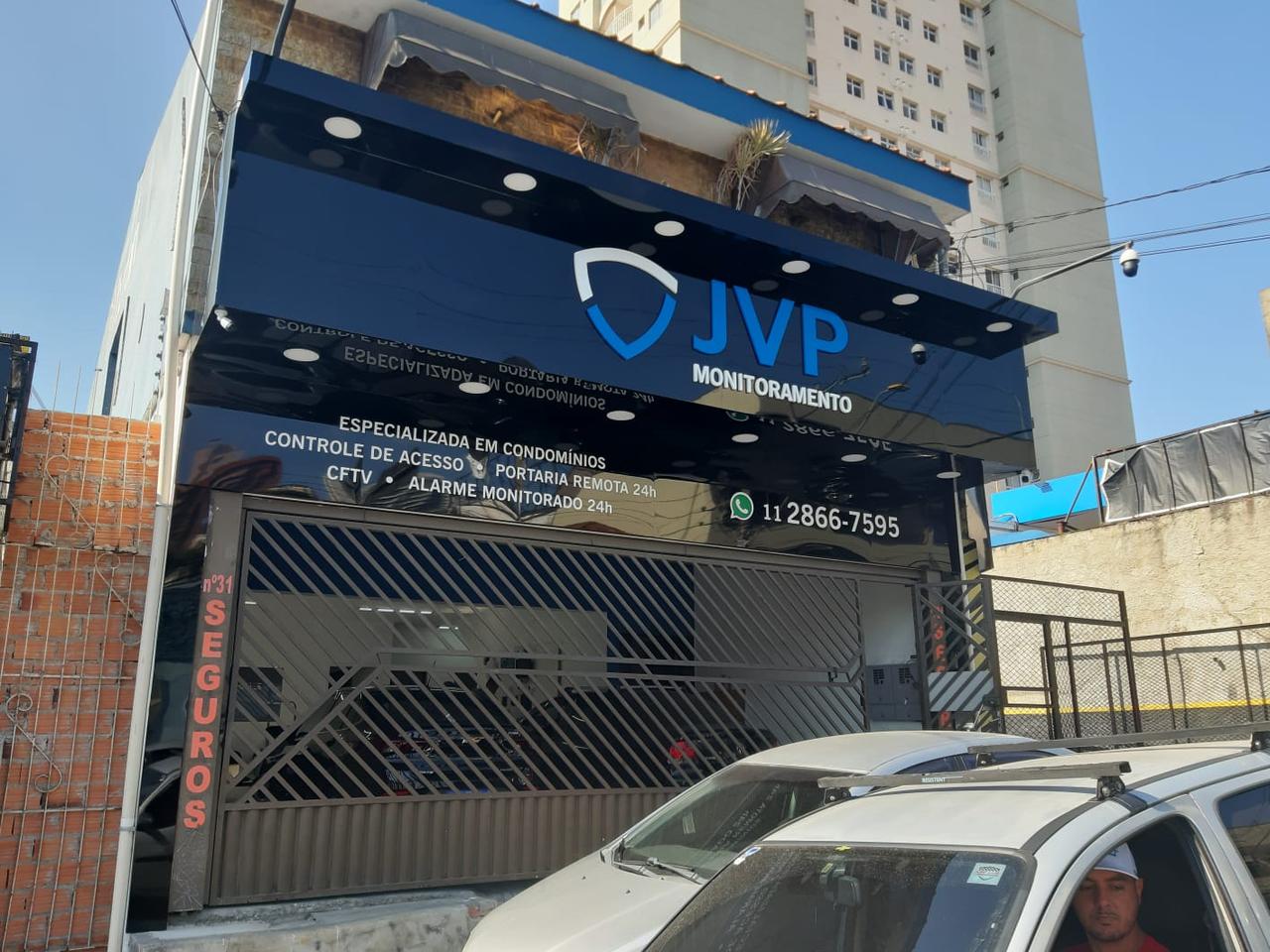 Fachada em ACM preto brilhante da JVP Monitoramento com letras caixa iluminadas e sinalização